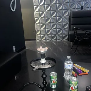 a black table with drinks and snacks on it