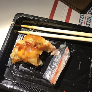 a piece of sushi and chopsticks