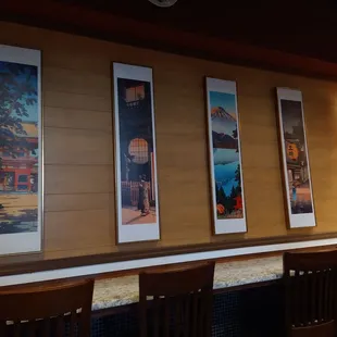 a row of paintings on the wall