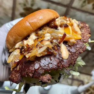 a hand holding a hamburger