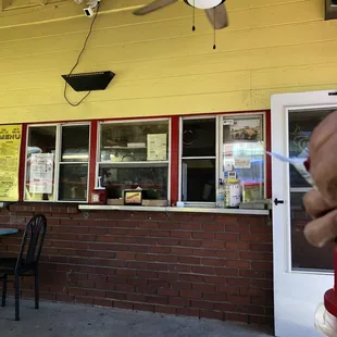 a person holding a knife in front of a restaurant