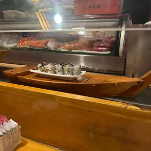 a wooden boat with sushi on it