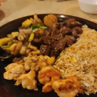 Steak, lobster, shrimp, fried rice, vegetables, and scallops.