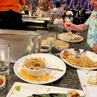 a man sitting at a table with plates of food