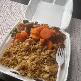 a take out container with rice and vegetables
