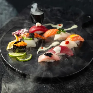a variety of sushi on a black plate