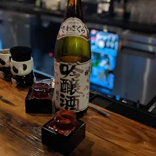 a bottle of sake sitting on a bar