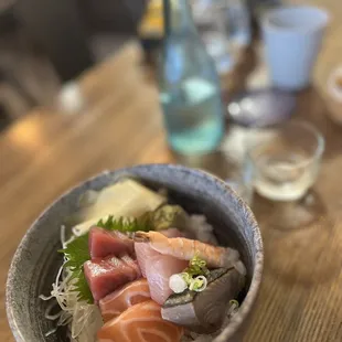 a bowl of sushi on a wooden table