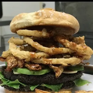 a burger with onion rings and lettuce