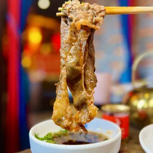 chopsticks holding up a piece of meat