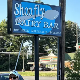 a woman standing in front of a sign