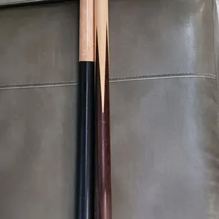 two cues on a leather couch