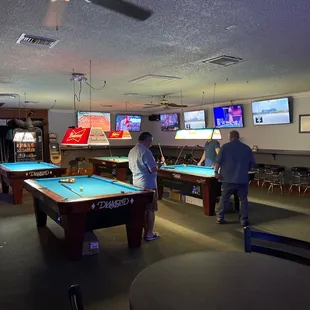 two men playing pool in a bar