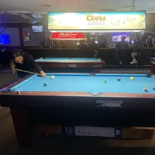 two people playing pool in a bar
