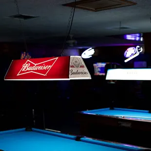 a pool table and a neon sign