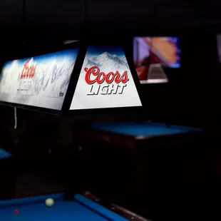 a pool table with a coca light sign on it