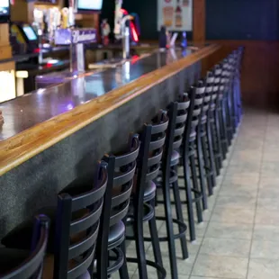 a row of bar stools at a bar