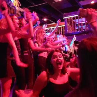 a group of people dancing in a bar