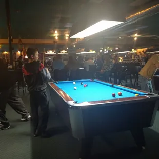 a group of people playing a game of pool