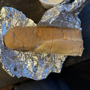 ows a sandwich wrapped in tin foil