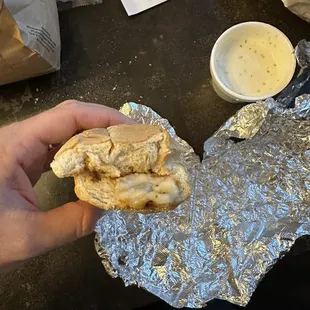 ows a hand holding a sandwich