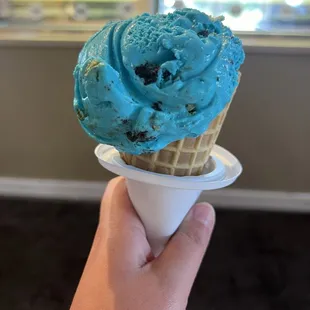 One scoop of Cookie Monster on a waffle cone