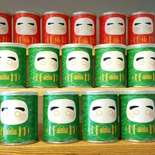 Daruma tin cans contain almond milk chocolates, and 2 round magnets in the back for eyes when your wish comes true.