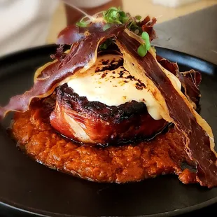 Pork chop topped with crispy prosciutto and mozzarella