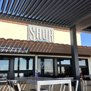 the outside of a restaurant with tables and chairs