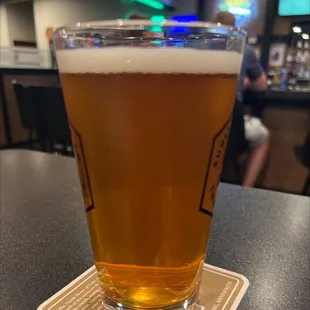 a glass of beer on a coaster