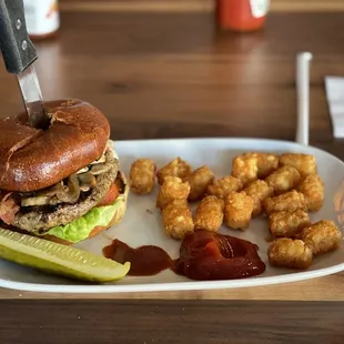 a burger and tater tots on a plate