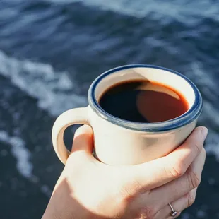 a person holding a cup of coffee