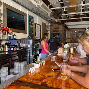 a woman sitting at a bar looking at her cell phone