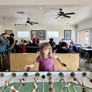 a little girl playing foosball