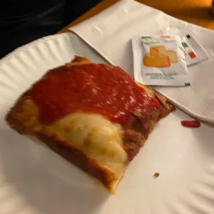 a slice of pizza on a paper plate