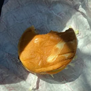 a half eaten sandwich on a piece of paper