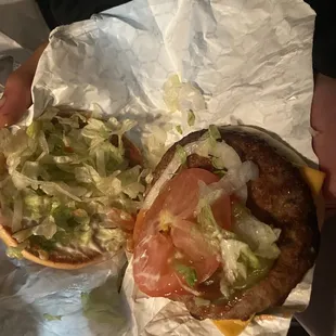 a hamburger with lettuce and tomatoes