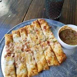 a plate of pizza and dipping sauce