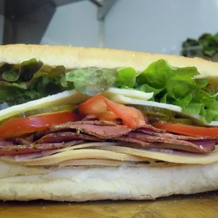 a sub sandwich with meat, cheese, tomatoes, and lettuce