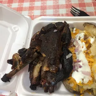 ribs and potatoes in a styrofoam container
