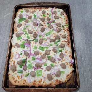 a pizza with meatballs and onions