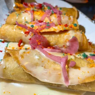 Roll Ups- 4 Rolled Tortillas loaded with Chicken /Chihuahua / Potato + Yuca. Topped with Queso Blanco