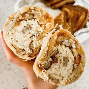 a person's hand holding a sandwich