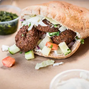 a meatball sandwich with lettuce and tomatoes
