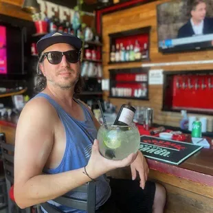 a man sitting at a bar with a drink