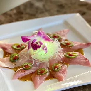 Hamachi carpaccio beautifully presented... there is a little green tea light glowing in the middle...