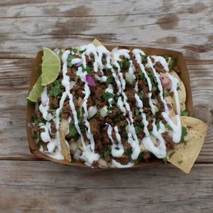 Freshly fried totopos are topped with our queso blanco, carne asada, onions, cilantro, and house crema. A definite crowd favorite.