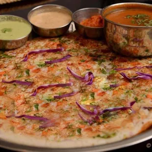 a flatbread pizza with vegetables and sauces