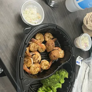 Shrimp basket grilled shrimp steamed broccoli with hush puppy and corn fritter with shrimp Coleslaw.