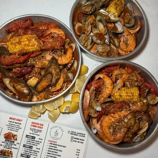 three bowls of seafood on a table